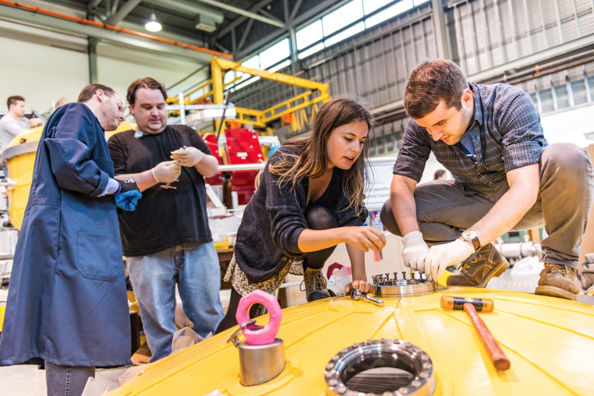 Researchers assembling the E­MMA mass spectrometer at T­RIUMF.